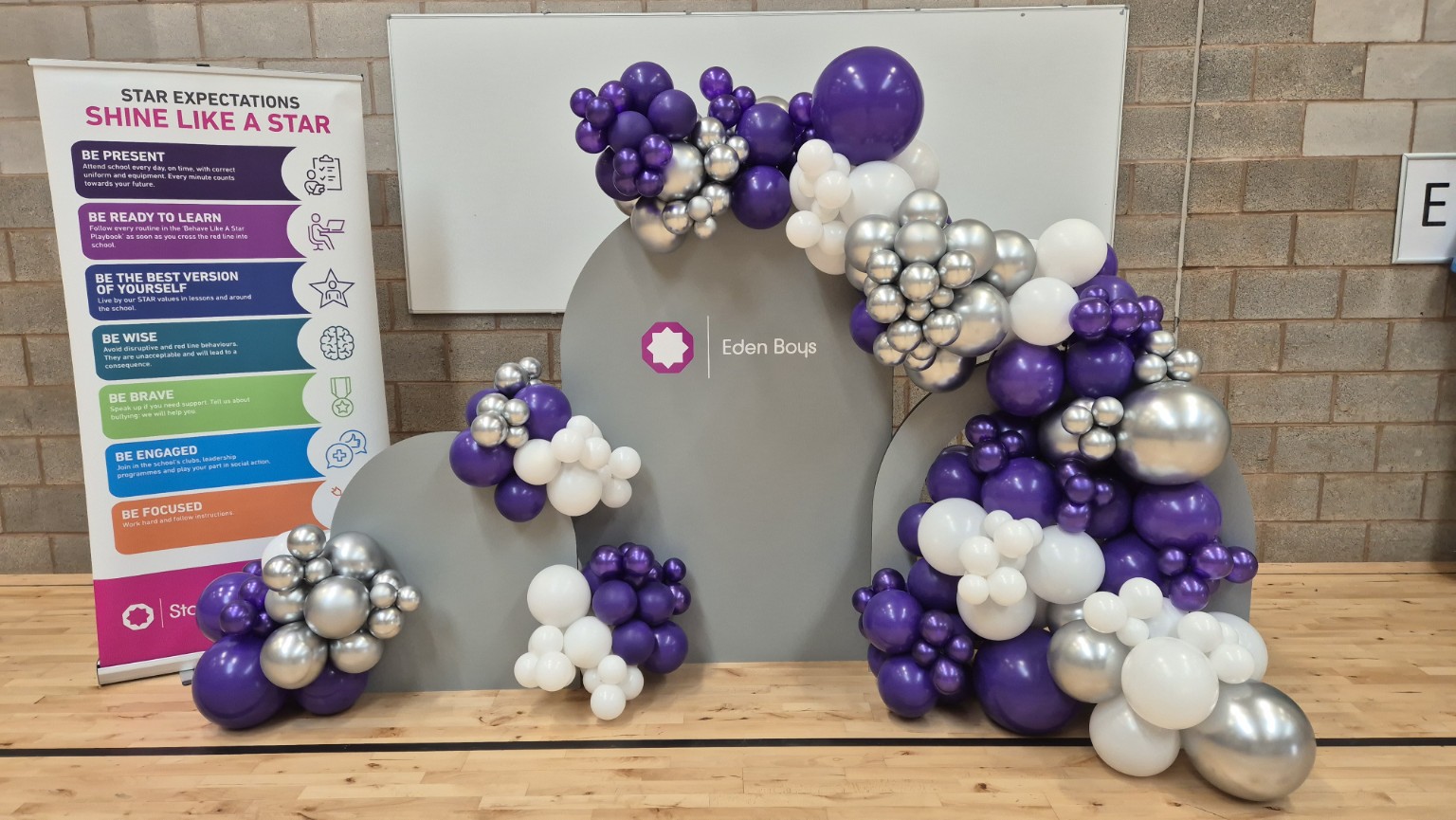 Branded triple backboard with purple silver and white balloons